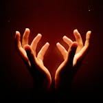 Illuminated hands reaching upward in a dark, warm setting, creating a sense of wonder.
